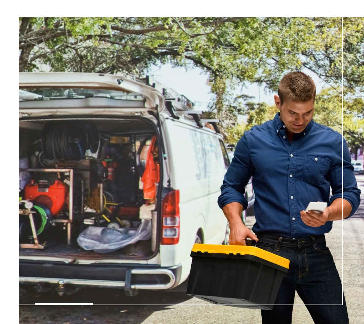 Worker holding toolbox on street
